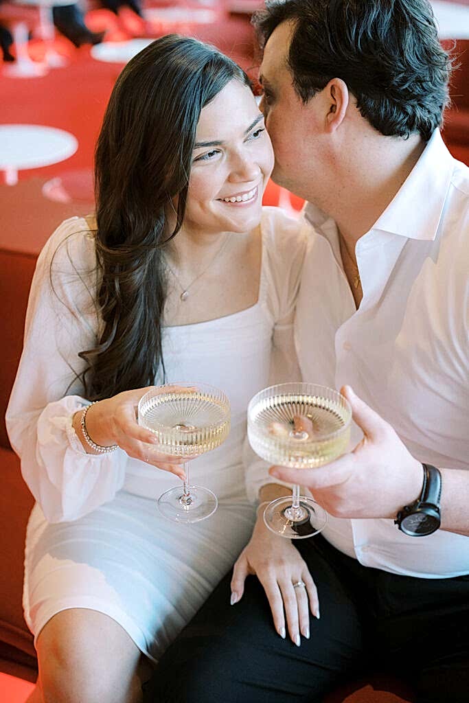 NYC Engagement Photos at TWA Hotel with couple holding champagne